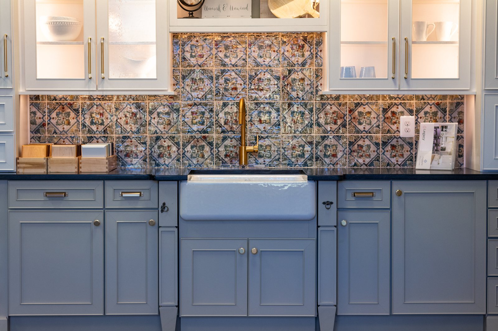 Blue gray cabinets under a patterned tile backsplash