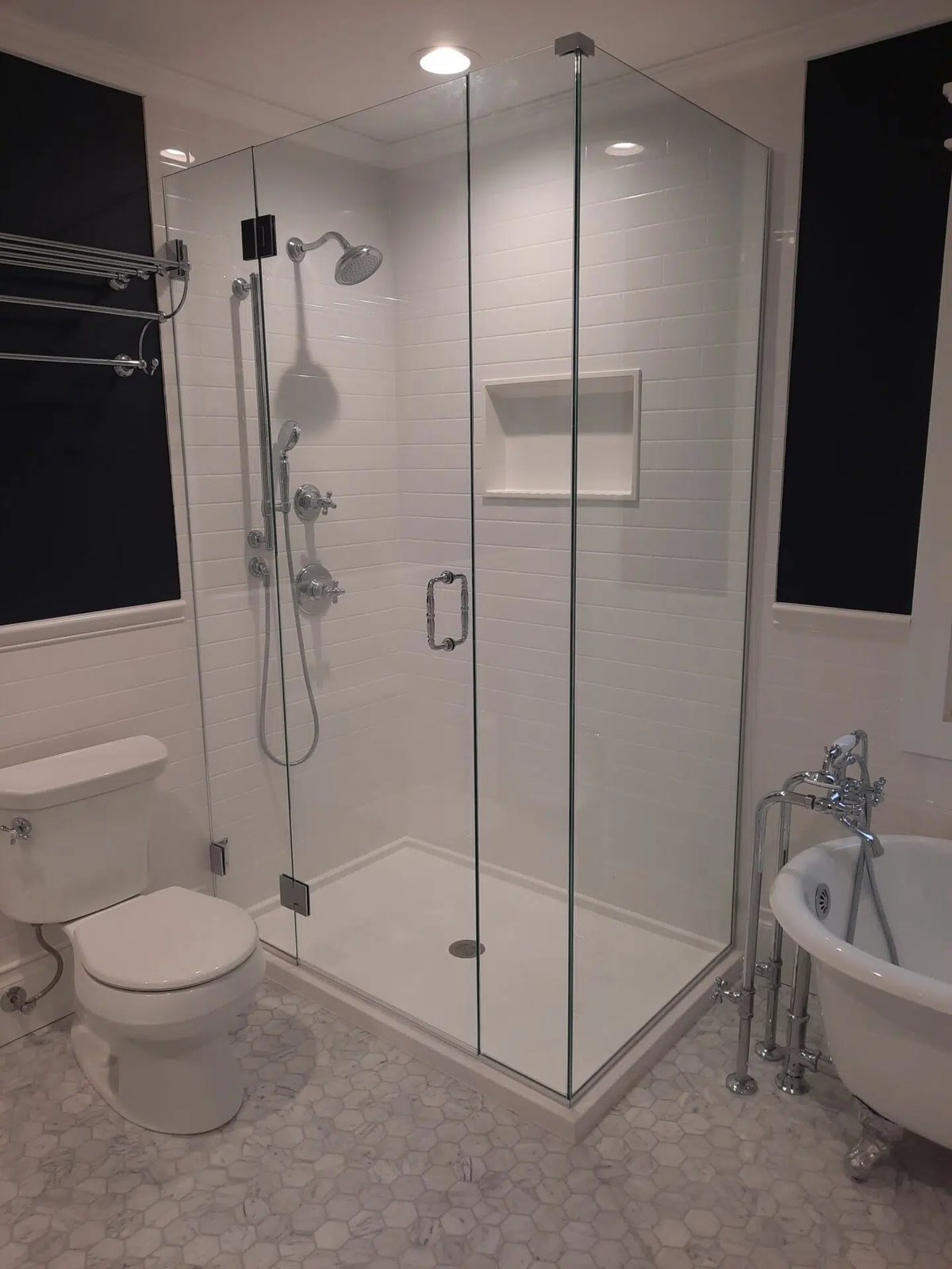 Glass corner shower with groutless wall panels and a recessed shelf niche, available at Sidney Kitchen and Bath in Winchester, VA