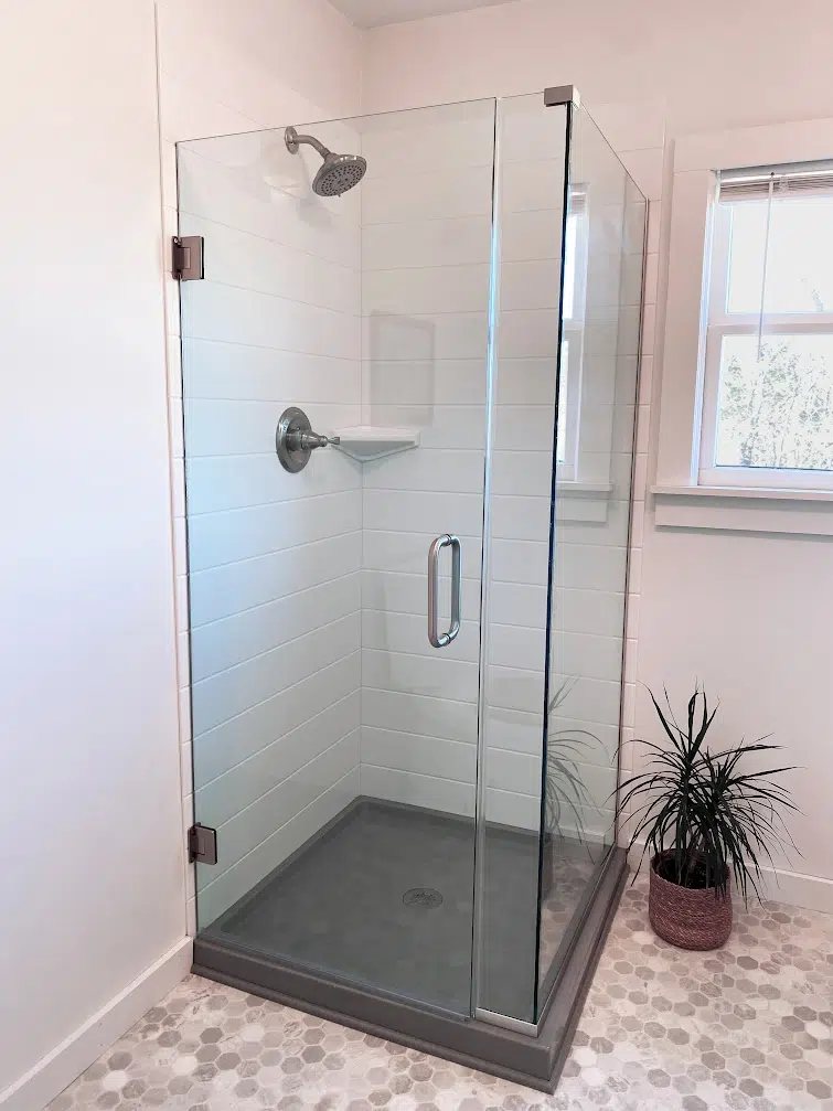 Corner shower with white groutless wall panels and a gray shower base, available at Sidney Kitchen and Bath in Winchester, VA
