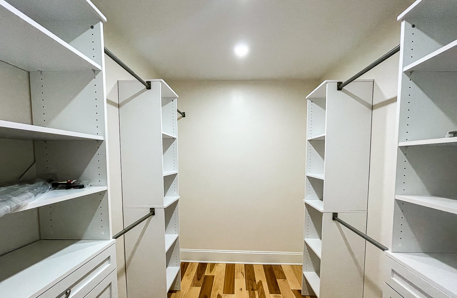 Walk in closet with shelving on both sides, a custom closet by Sidney Design and Build in Winchester, VA