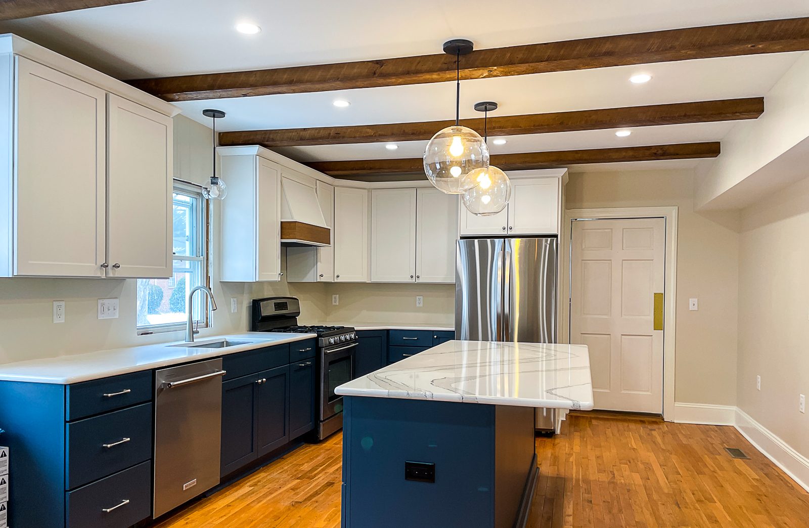 Navy lowers under exposed beams, a kitchen remodel by Sidney Design and Build in Winchester, VA