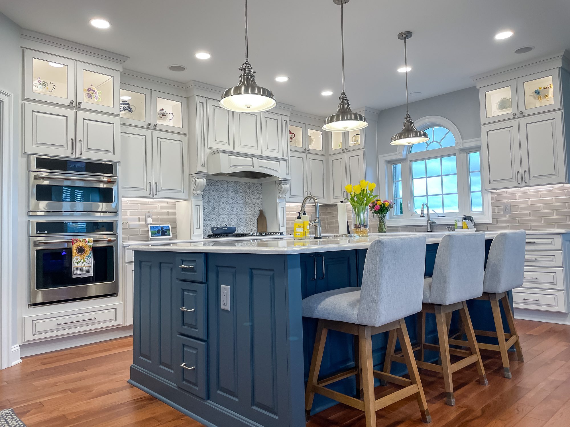 Navy island under a wall of white cabinets, a kitchen remodel by Sidney Design and Build in Winchester, VA