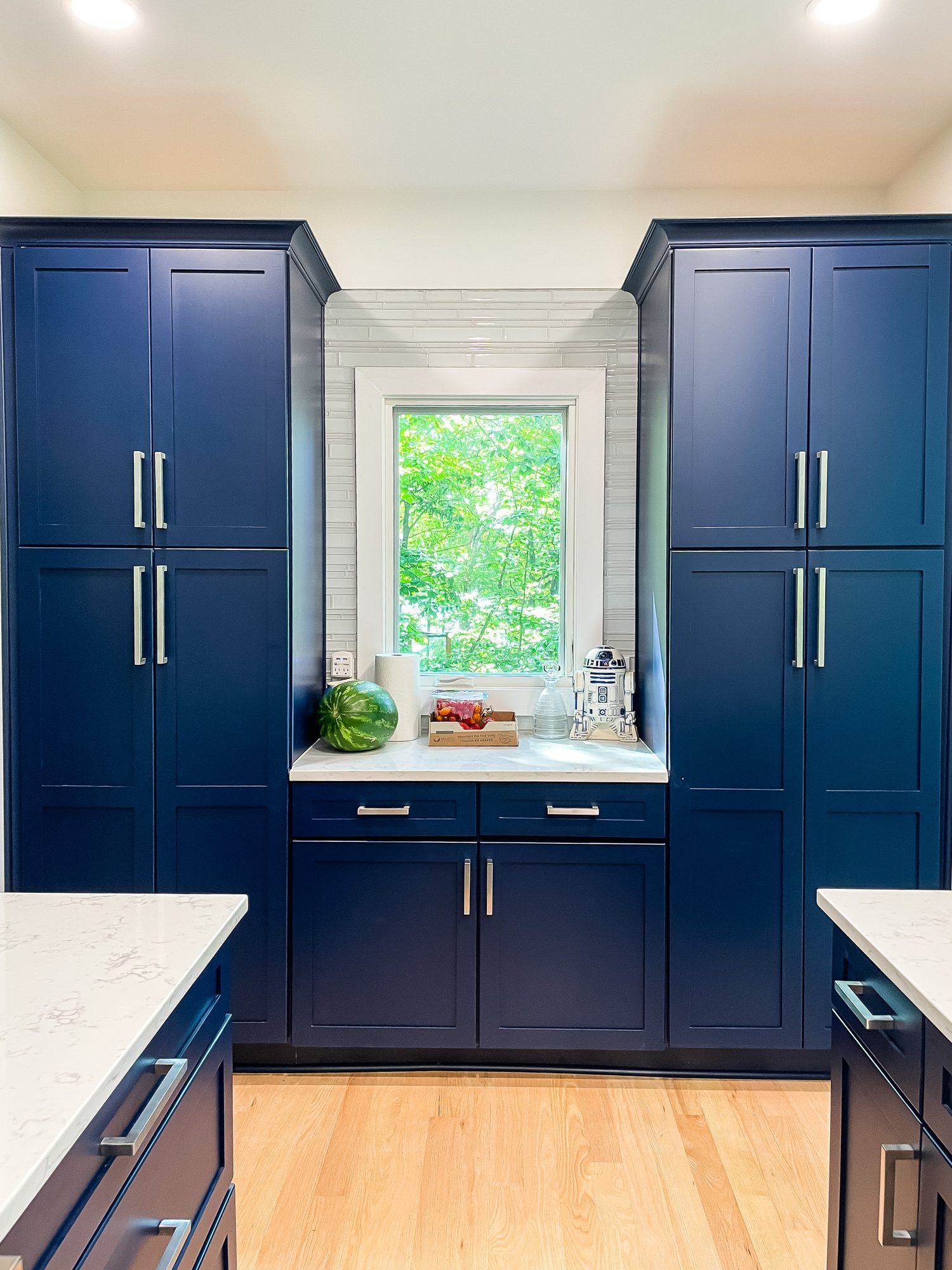 Navy cabinets framing the window, a kitchen remodel by Sidney Design and Build in Winchester, VA