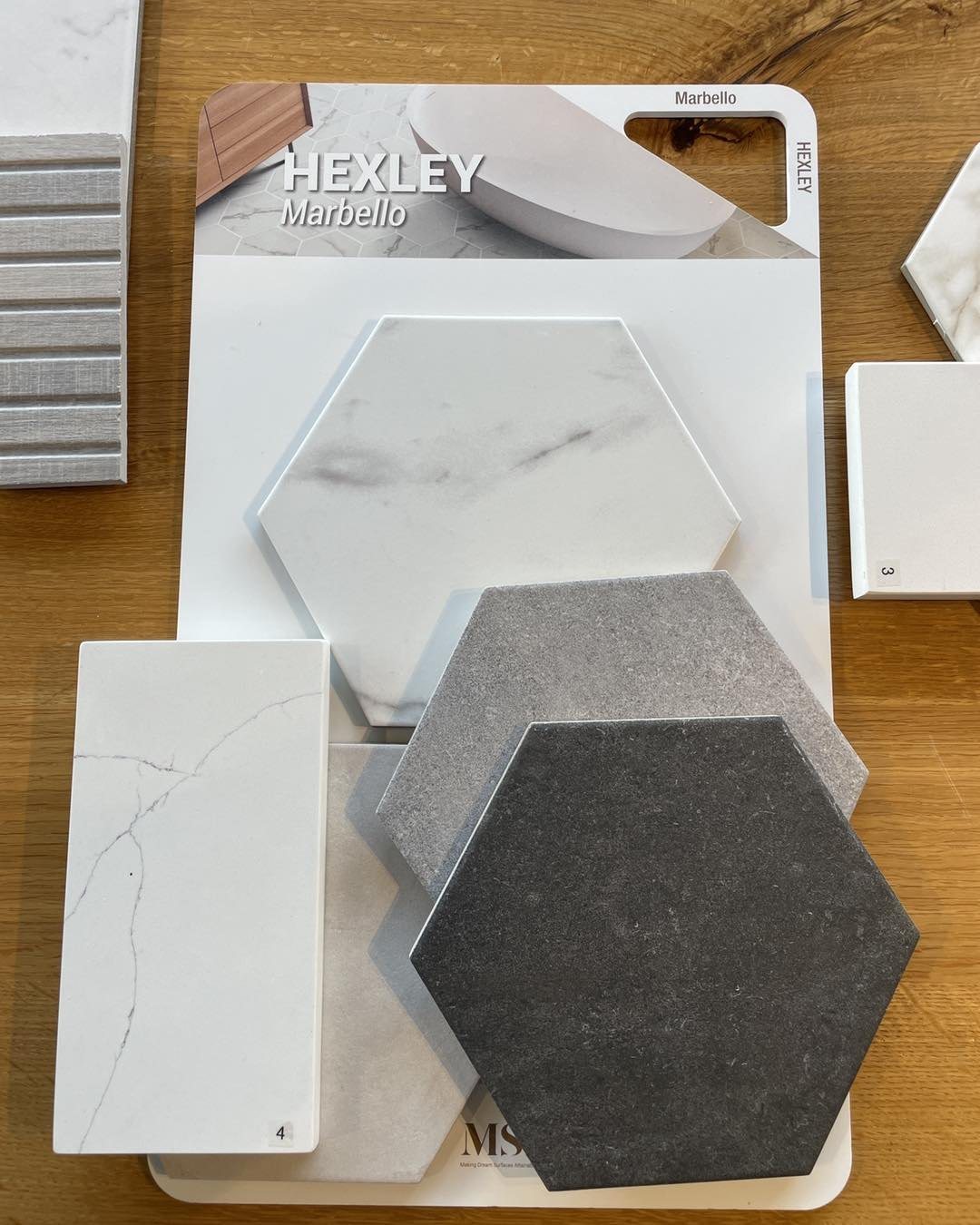 Hexagon tile and quartz countertop samples on a design table at Sidney Kitchen and Bath in Winchester, VA