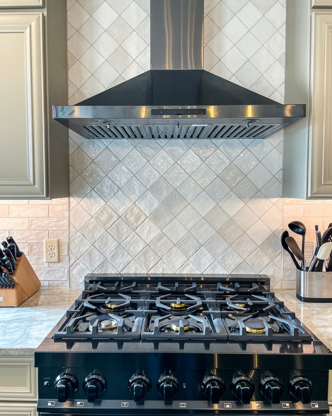 White patterned tile backsplash behind a range and hood in a Winchester, VA kitchen finished by Sidney Design and Build